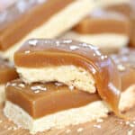 Close up of 2 stacked salted caramel bars with the caramel pulled on the top bar.