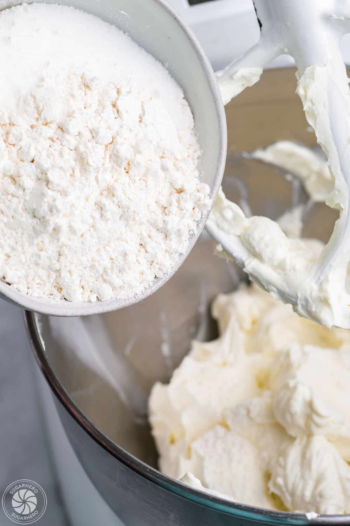 Adding flour and sugar to whipped cream cheese.