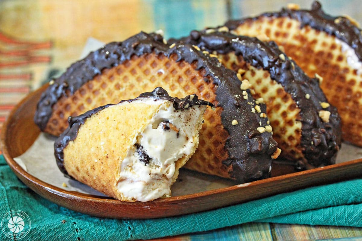 Four homemade choco tacos on a platter with the fourth broken in half.
