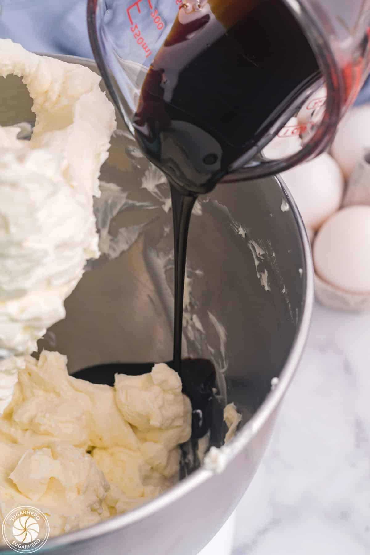 Molasses being poured into whipped cream cheese.