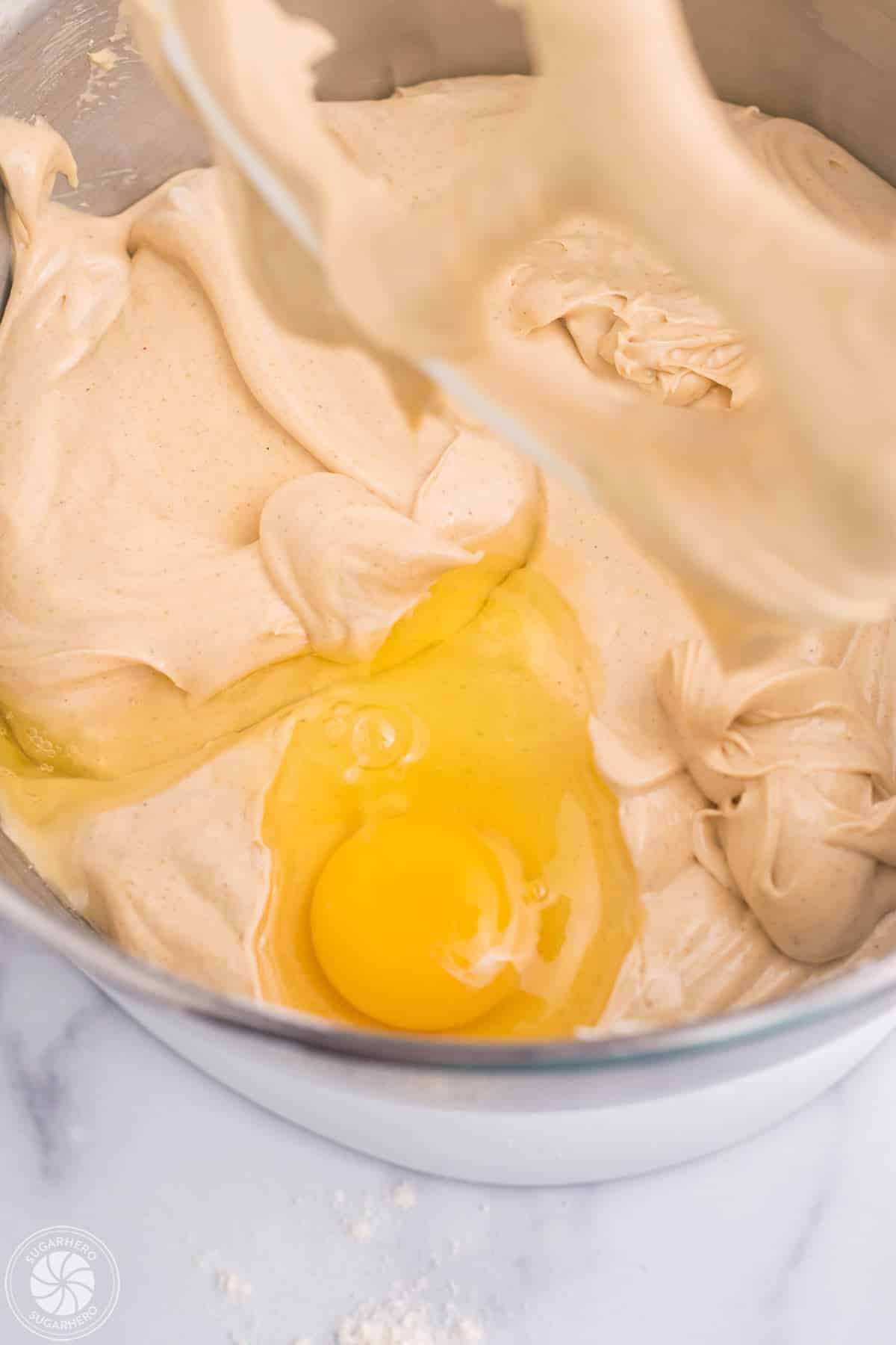 Mixing an egg into gingerbread cheesecake filling.