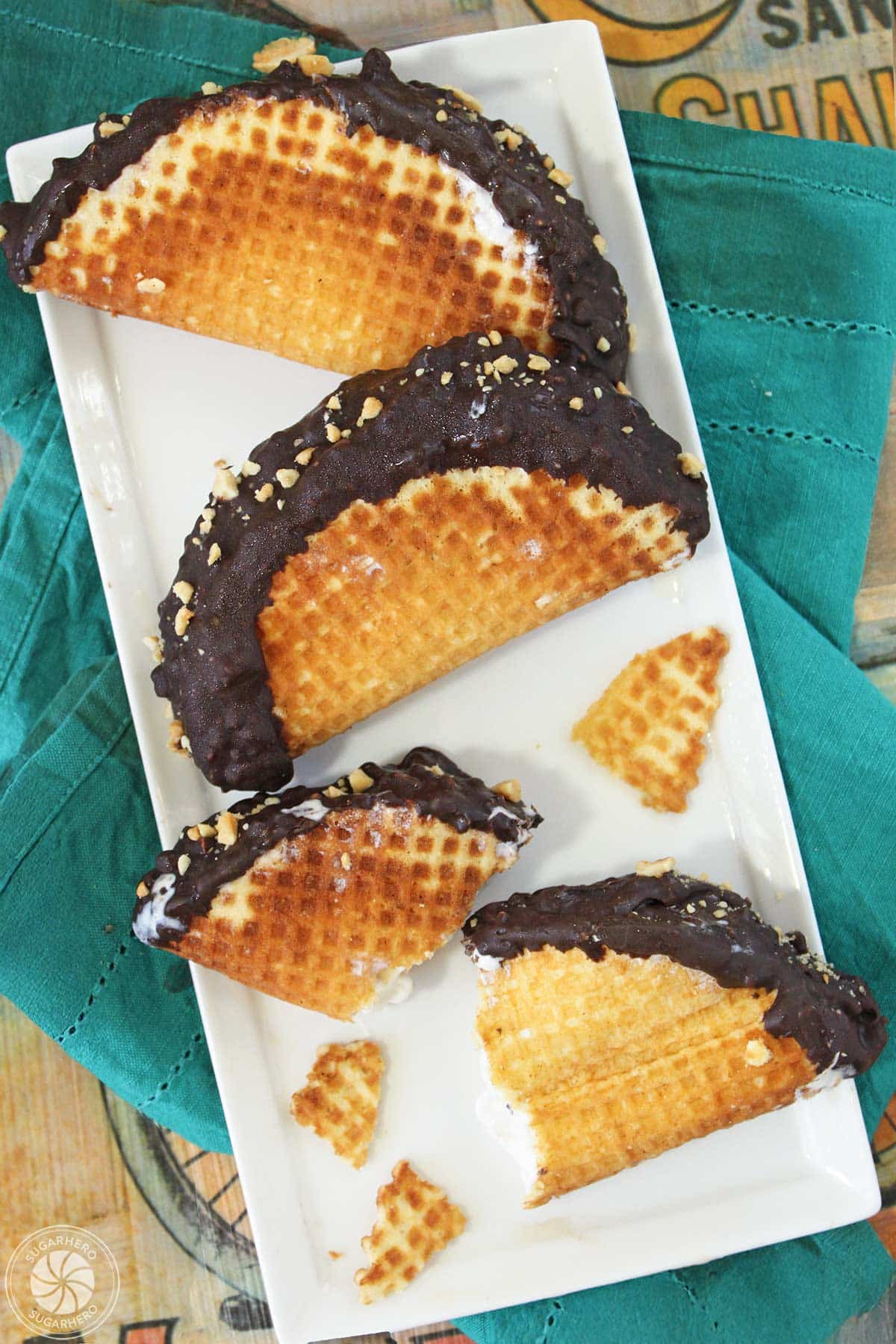 Three homemade choco tacos on a platter with the third broken into pieces.