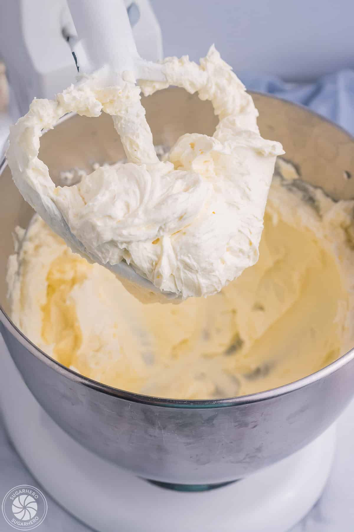 A paddle attachment covered in fluffly whipped cream cheese.