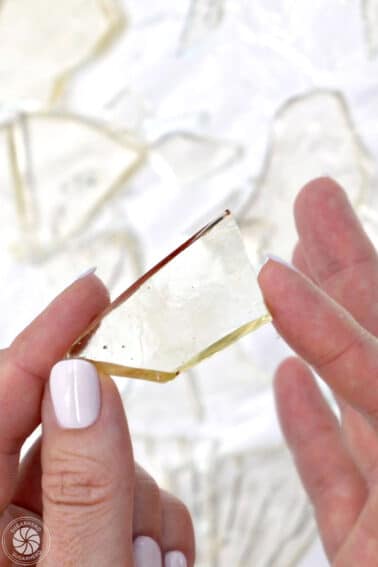 Hand showing a piece of edible sugar glass.