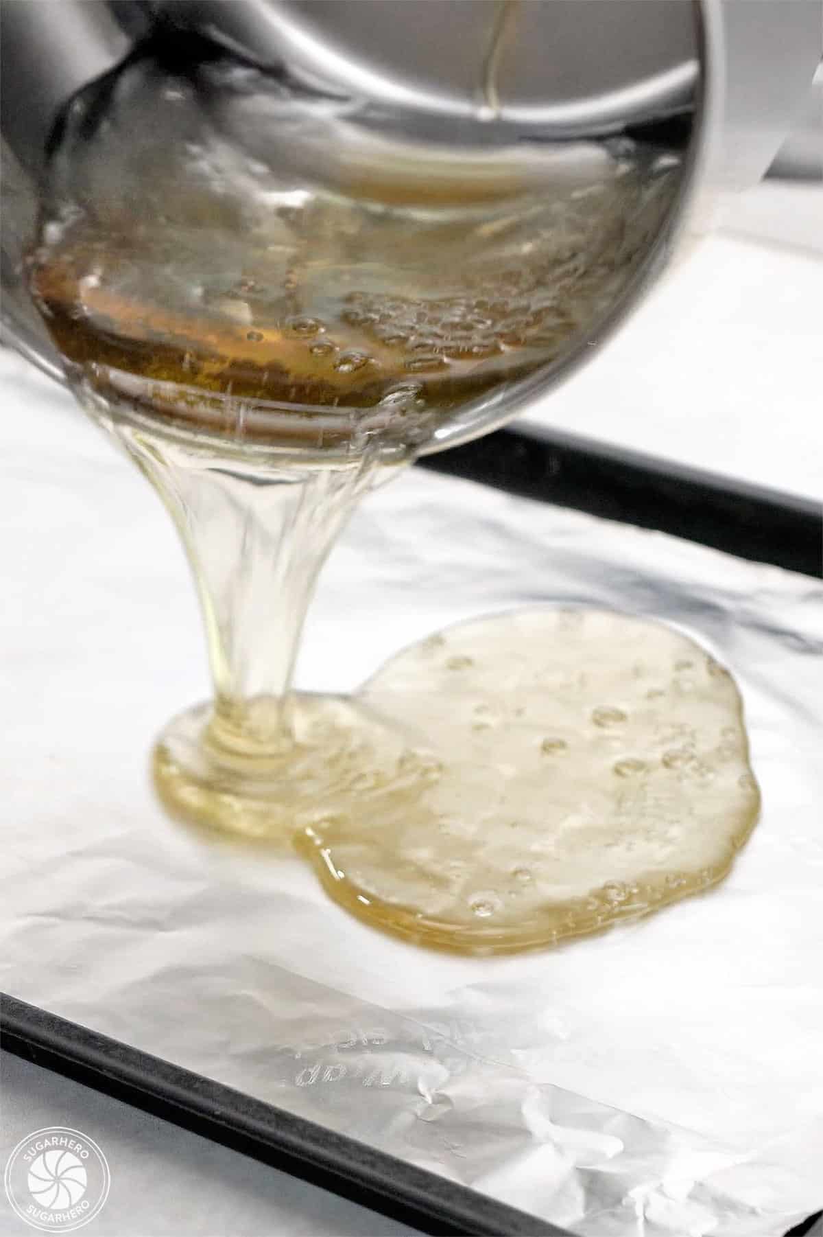 Pouring hot liquid sugar onto a tinfoil lined baking sheet.