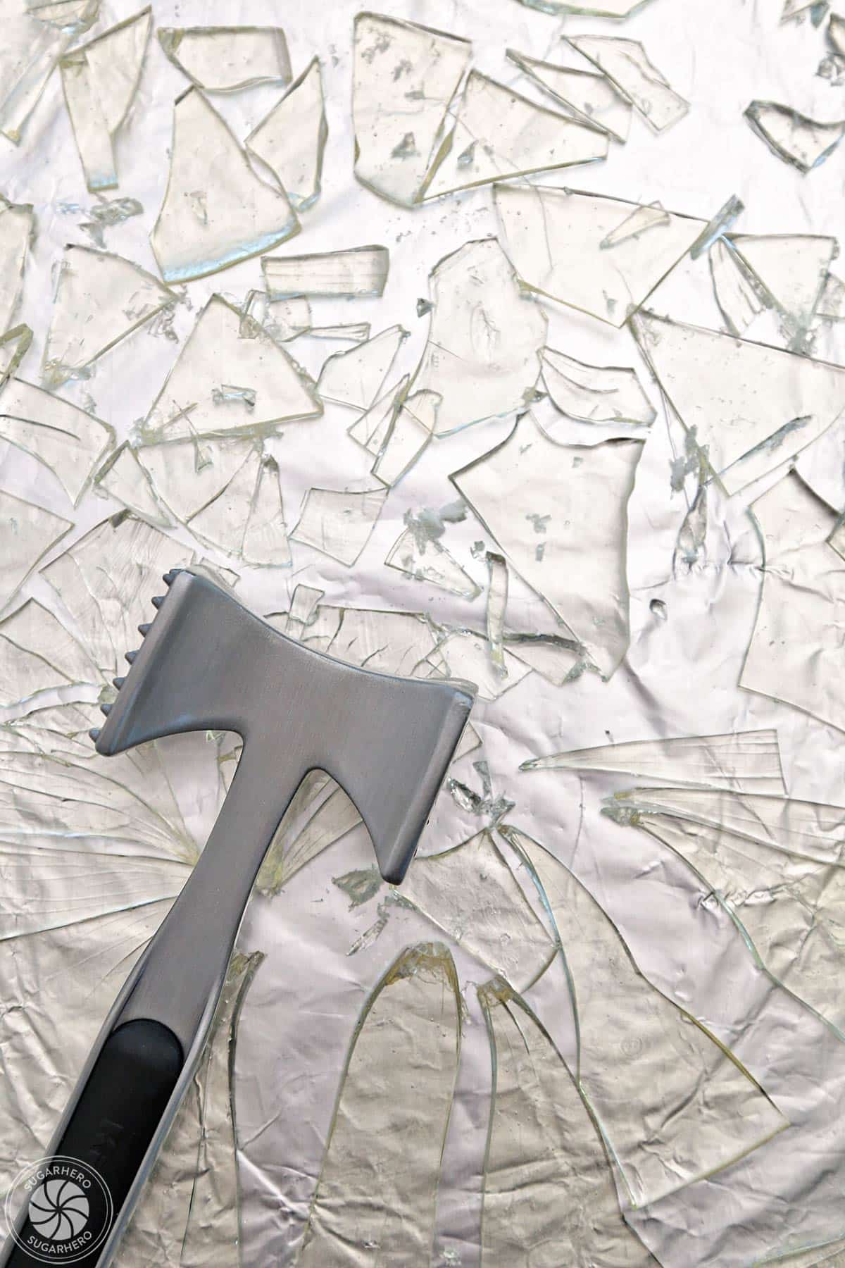 Sugar glass on a tin foil surface with a kitchen mallet.