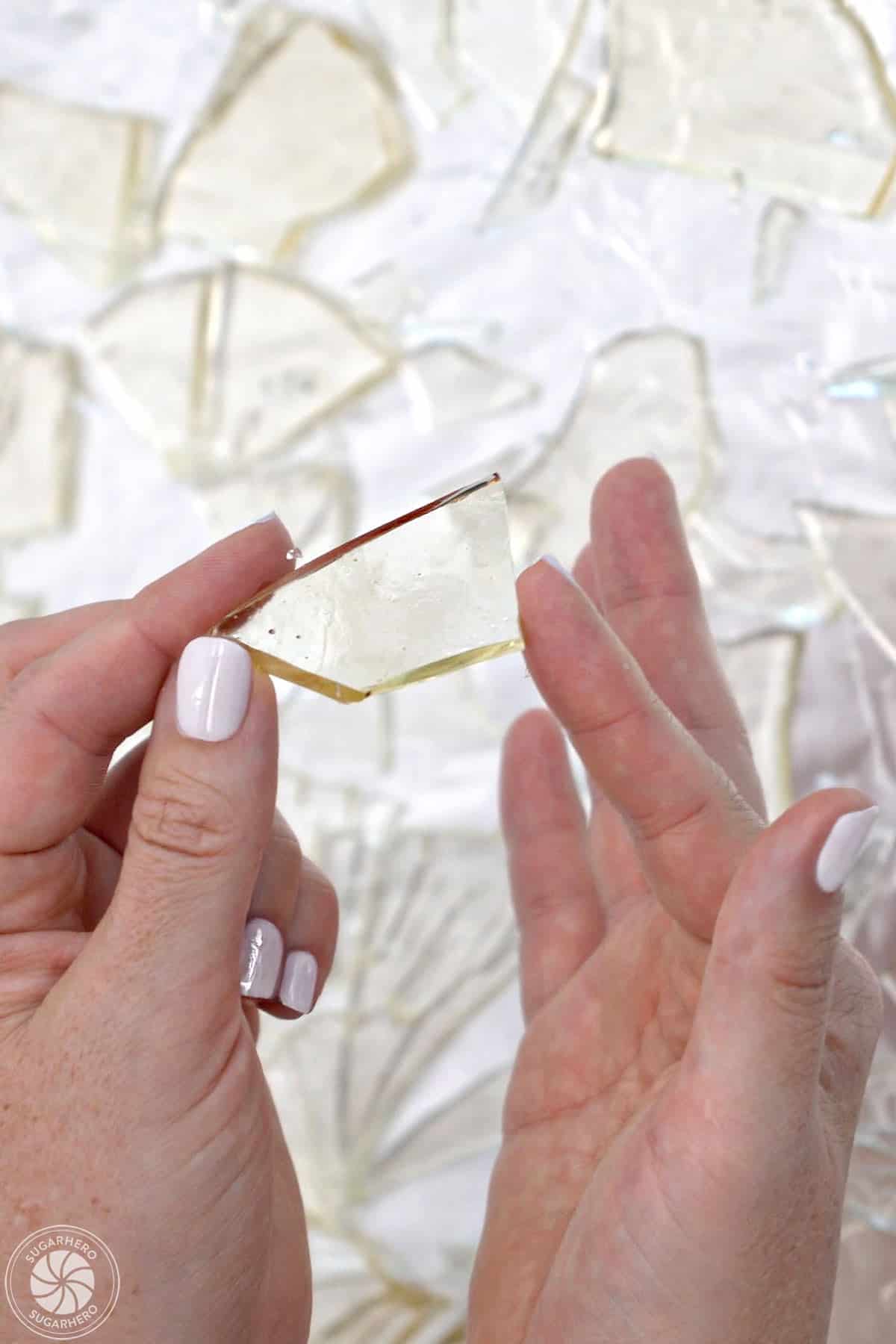 Hand holding up a piece of sugar glass.