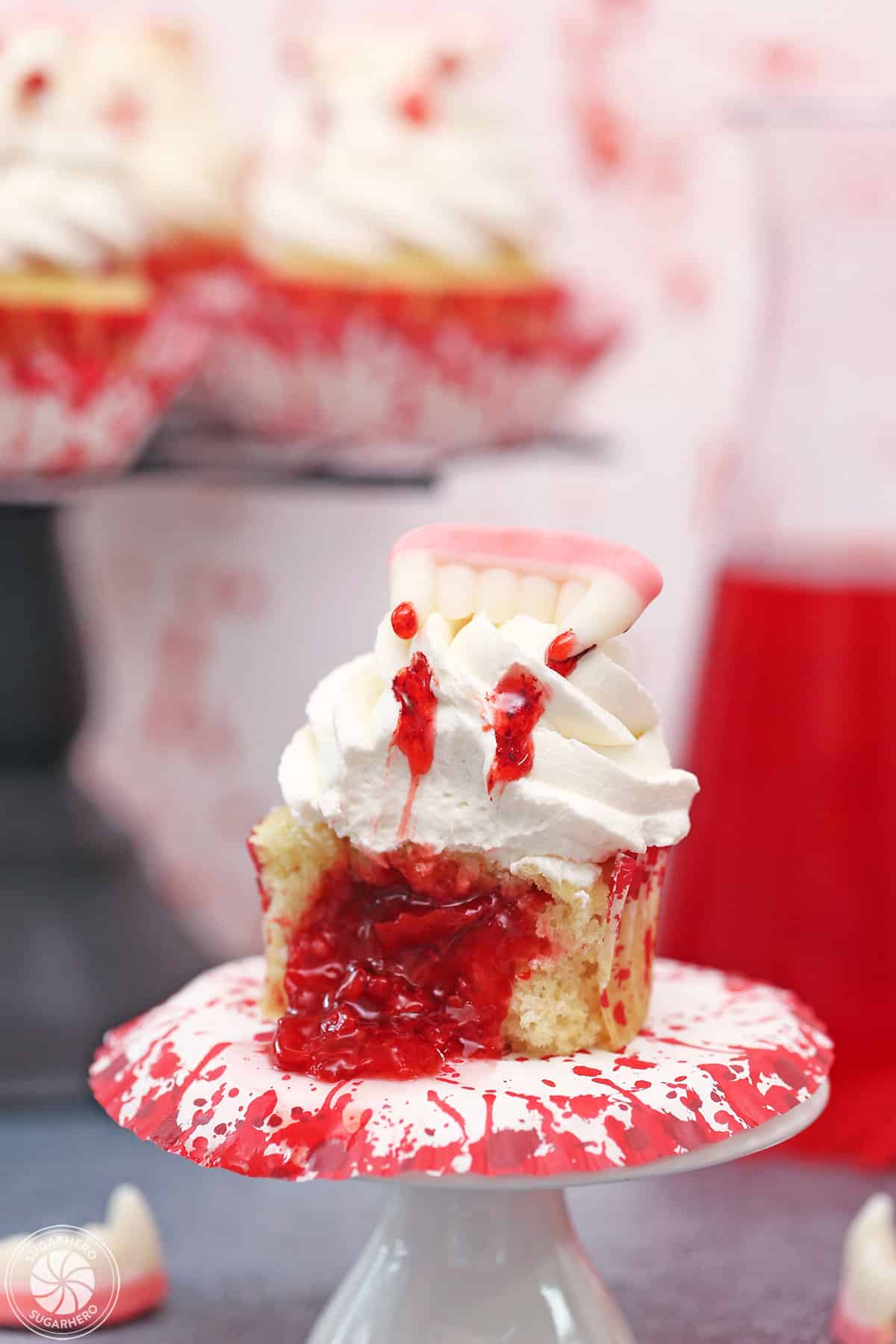 Close up of a vampire bite cupcake that's been cut to show oozing cherry filling.