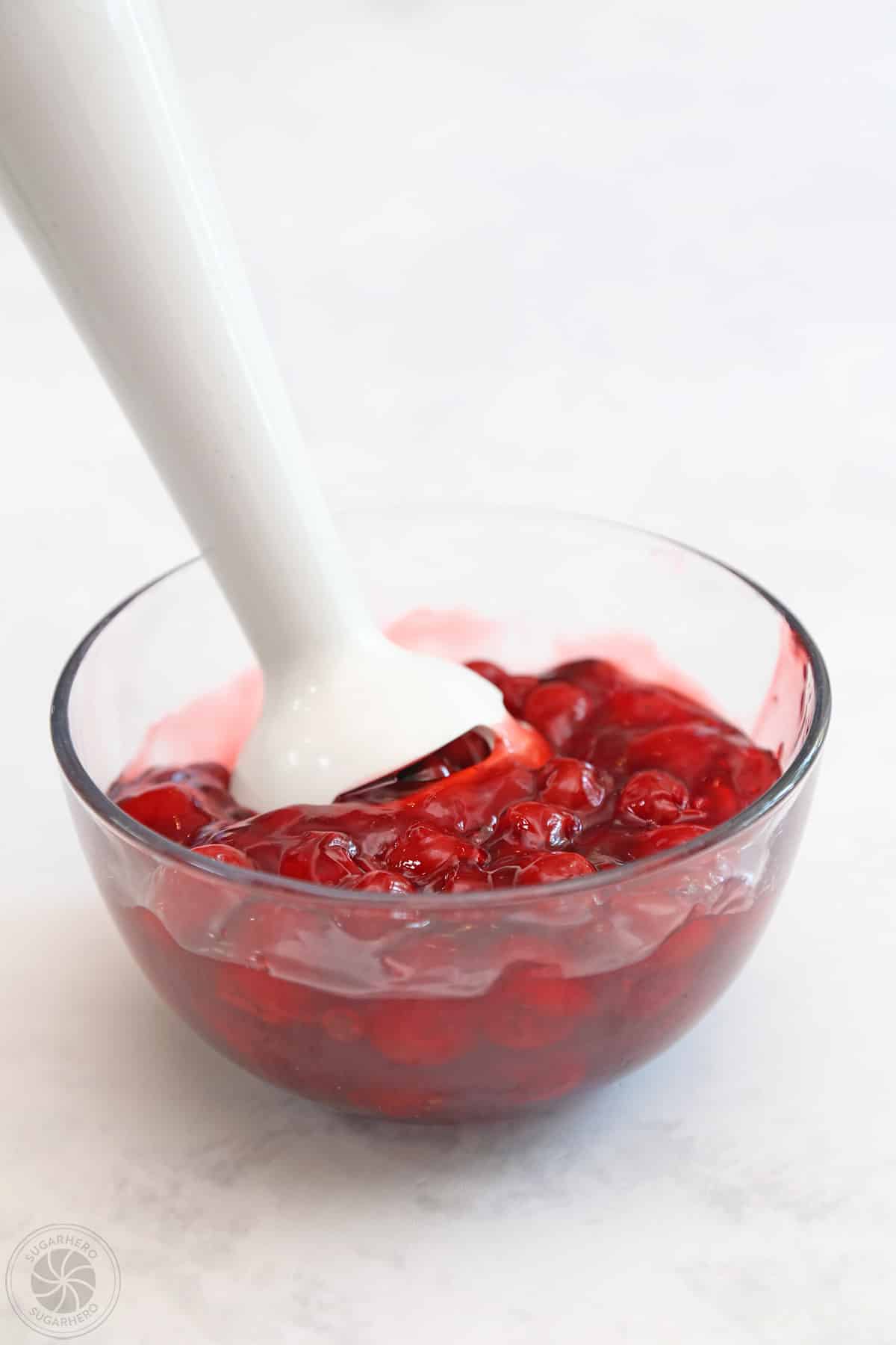 Using an immersion blender to chop cherry filling.