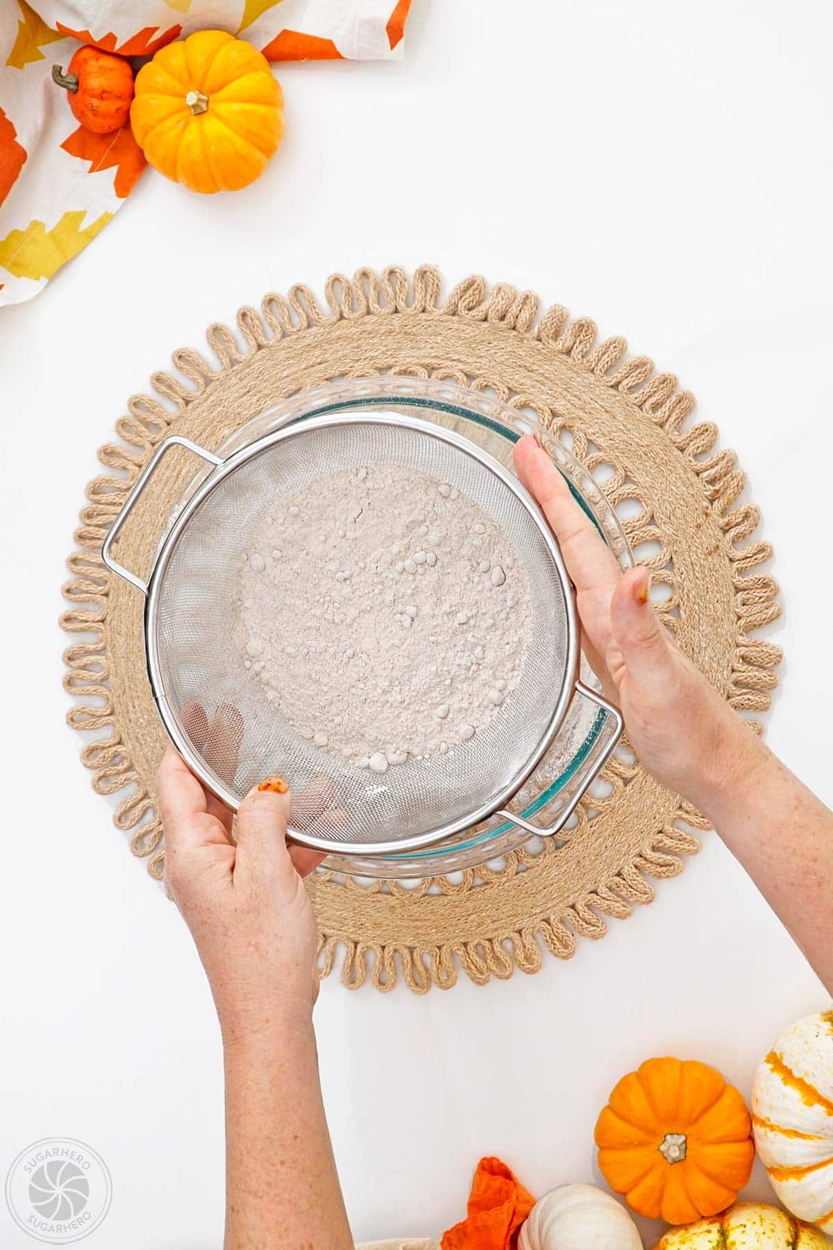 Sifting cake mix into a mixing bowl.