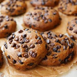 Close up of two pumpkin chocolate chip cookies.