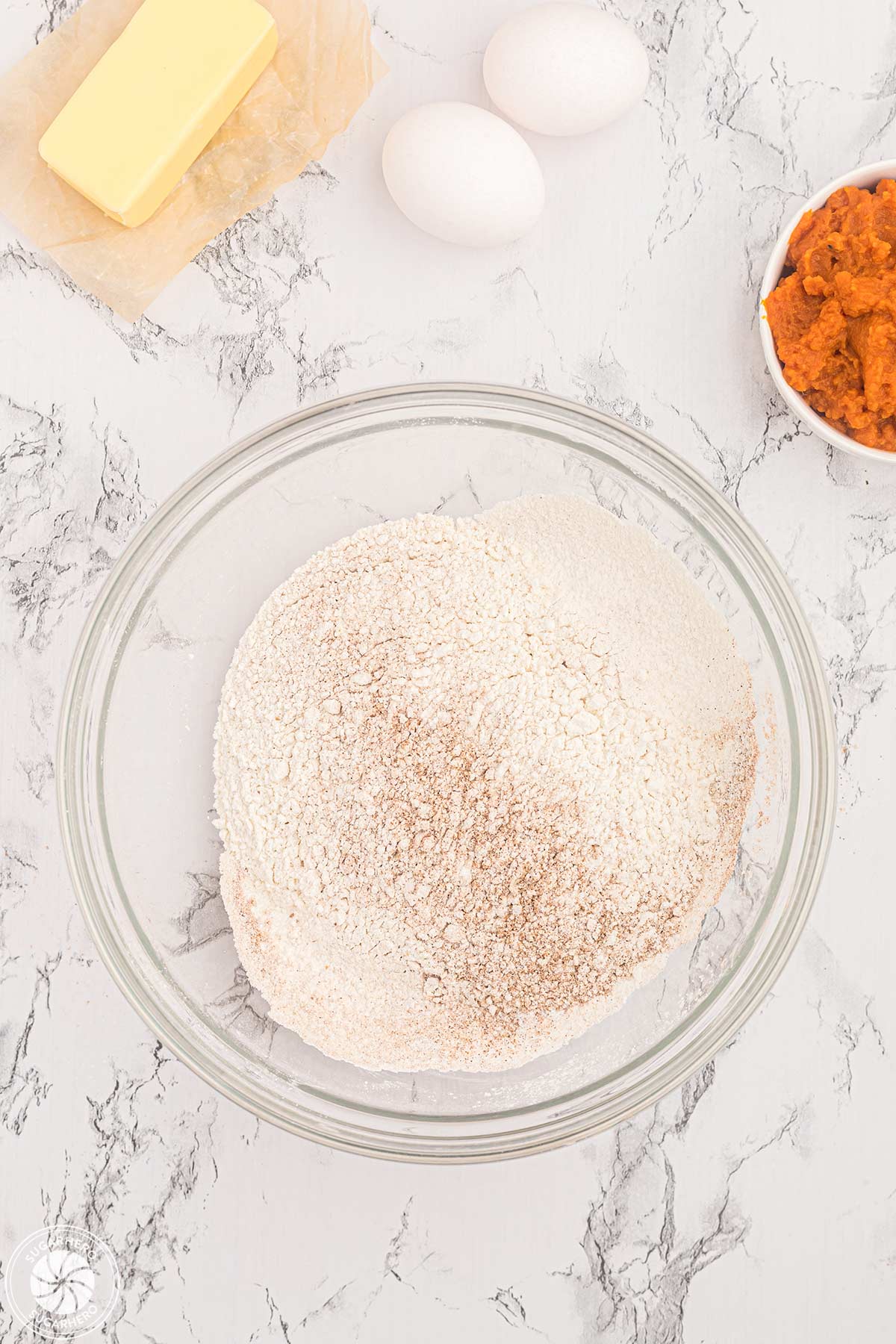 Sifted dry ingredients in a glass mixing bowl.