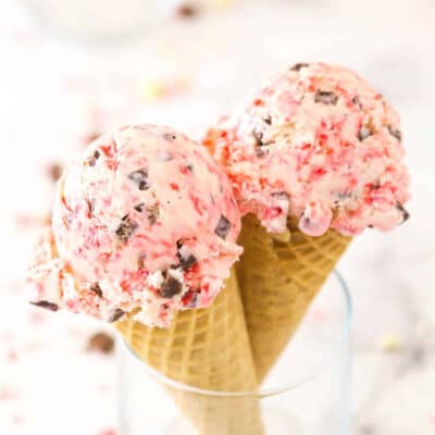 Two ice cream cones with no-churn peppermint ice cream scooped on top.