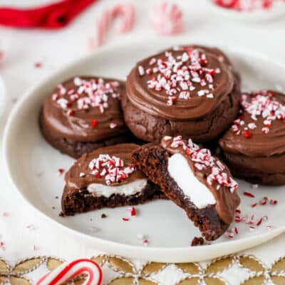 A plate of peppermint hot chocolate cookies with the front cookie cut in half to show center.