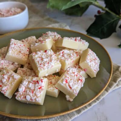 A plate of white chocolate peppermint fudge in a pile.