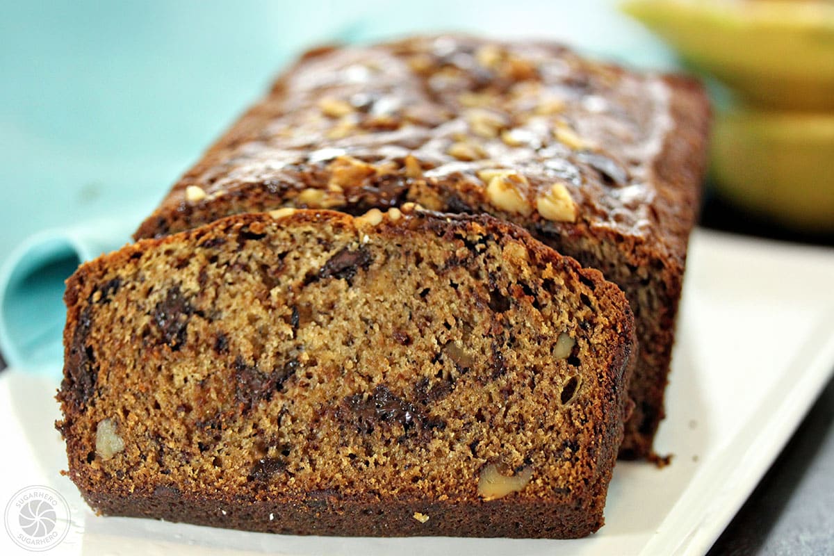 The Best Banana Bread | From SugarHero.com Close up of a slice of banana bread leaning up against the rest of the loaf.