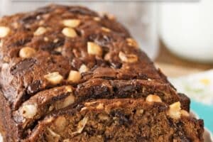 An image of banana coconut macadamia nut bread with text overlay for pinterest.